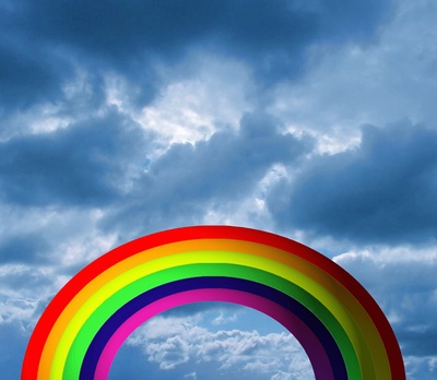 Bunter Regenbogen vor wolkigem Himmel