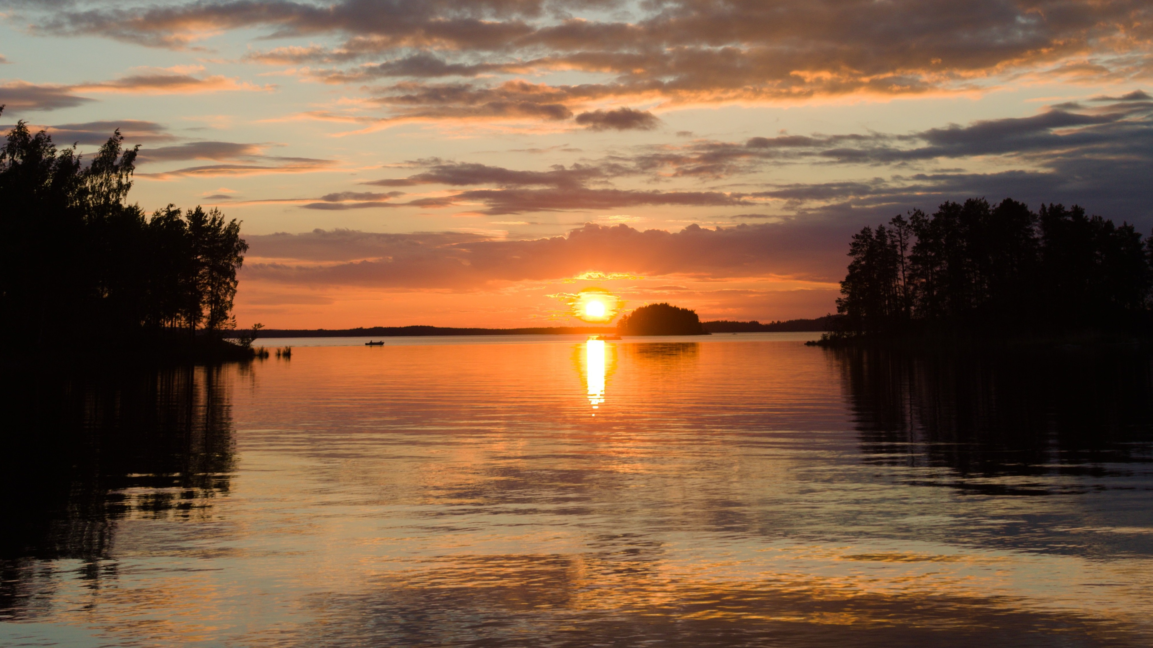 Sommernachtstraum Sommernachtstraum - die untergehende Sonne spiegelt sich im glatten mehr, links und rechts ragt Schilf ins Bild. Über dem Wasser hängen dunkle Wolken, aber die Luft sieht klar und rein aus.