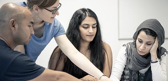 Eine Lehrkraft mit Schüler:innen des Deutschunterrichts von Deine Chance