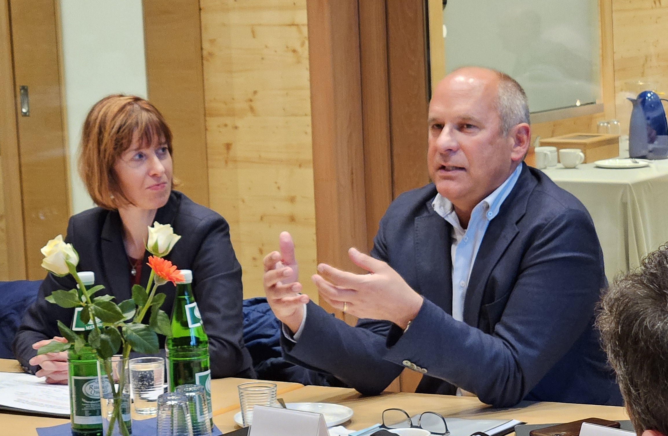 Sozialministerin Heike Hormann und Innenminister Roman Poseck sitzen nebeneinander an einem Tisch im Gemeindehaus Dauernheim.