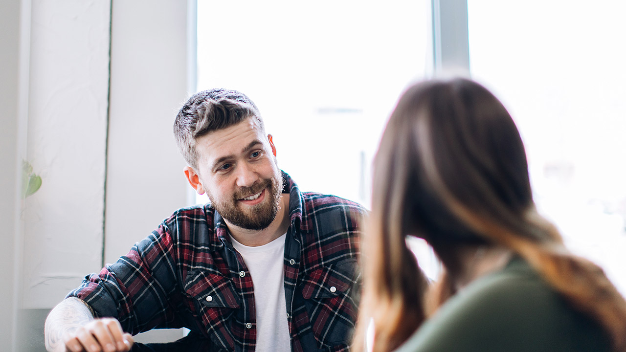 Mentale Gesundheit Ein jüngerer Mann (Sozialarbeiter) berät eine Schülerin
