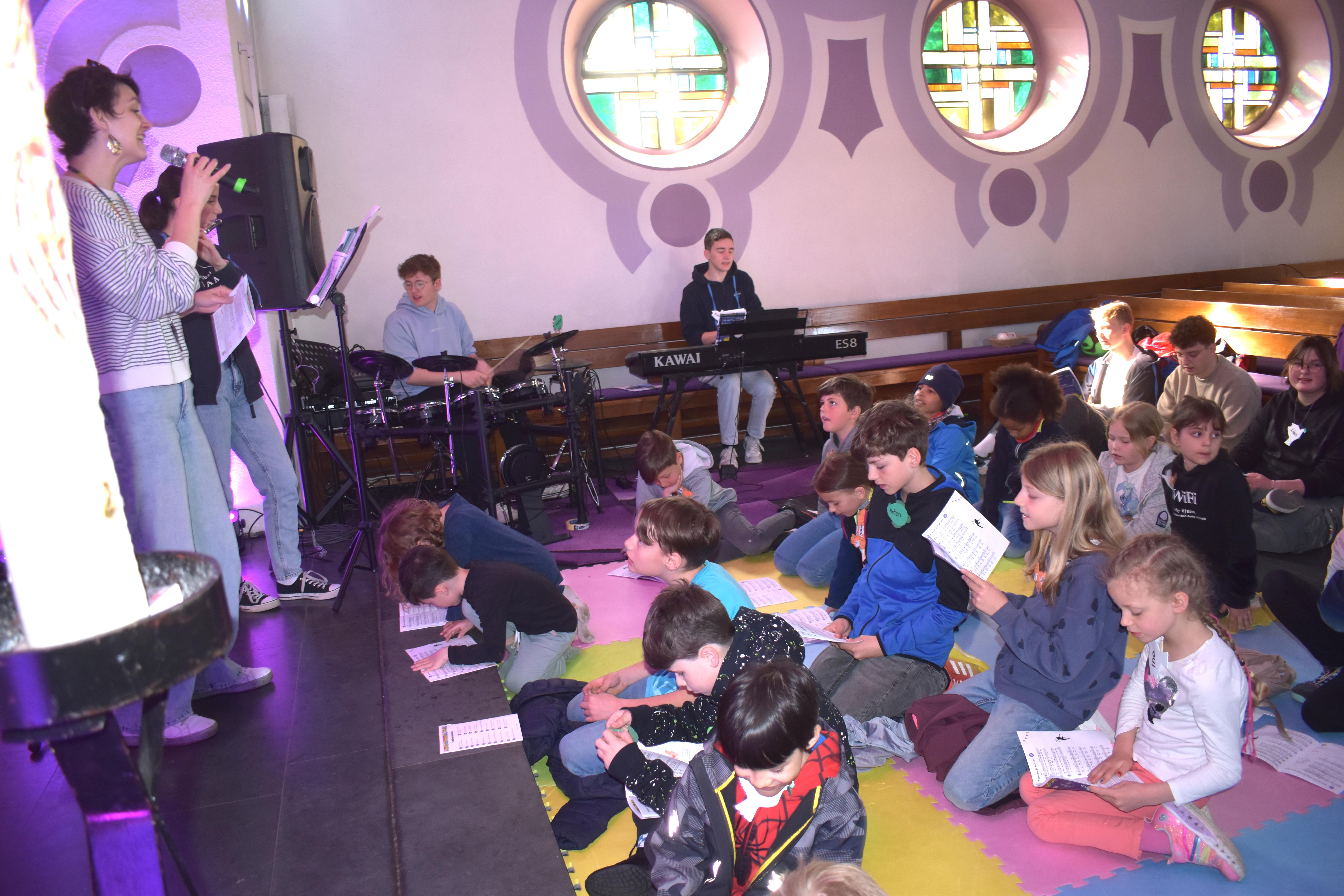 Gemeindepädagogin Mairine Luttrell mit der Jugendband der Kirchengemeinde und dem Team der Kinderbibeltage bei der Eröffnung