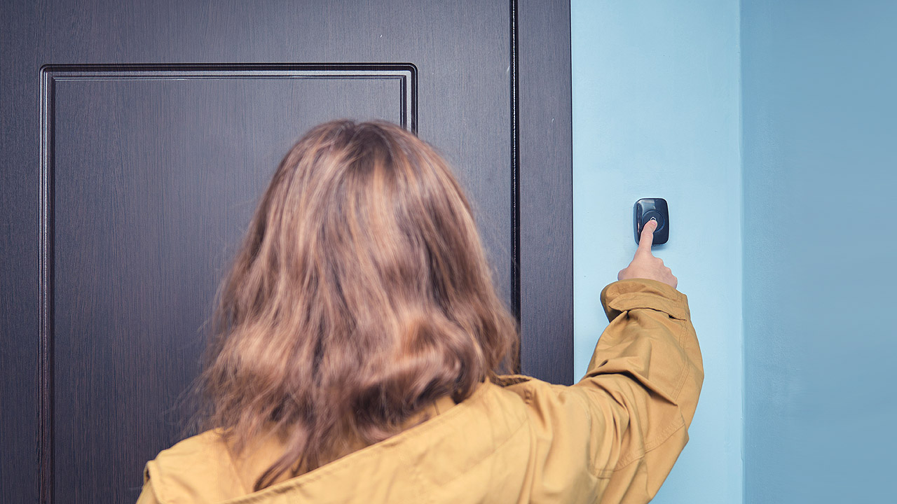 Eine Frau klingelt an einer Tür