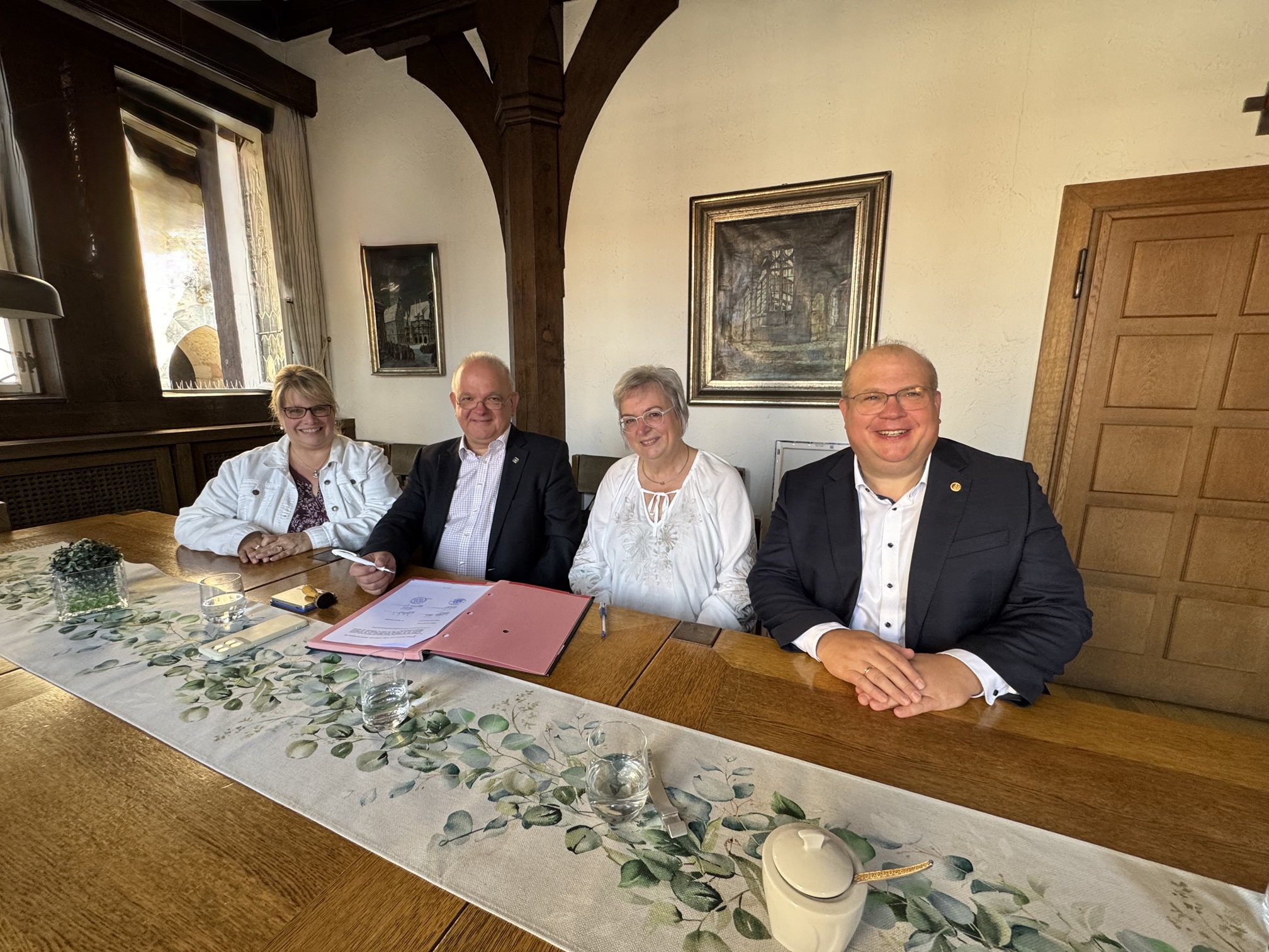 Vier Menschen sitzen an einem Tisch.