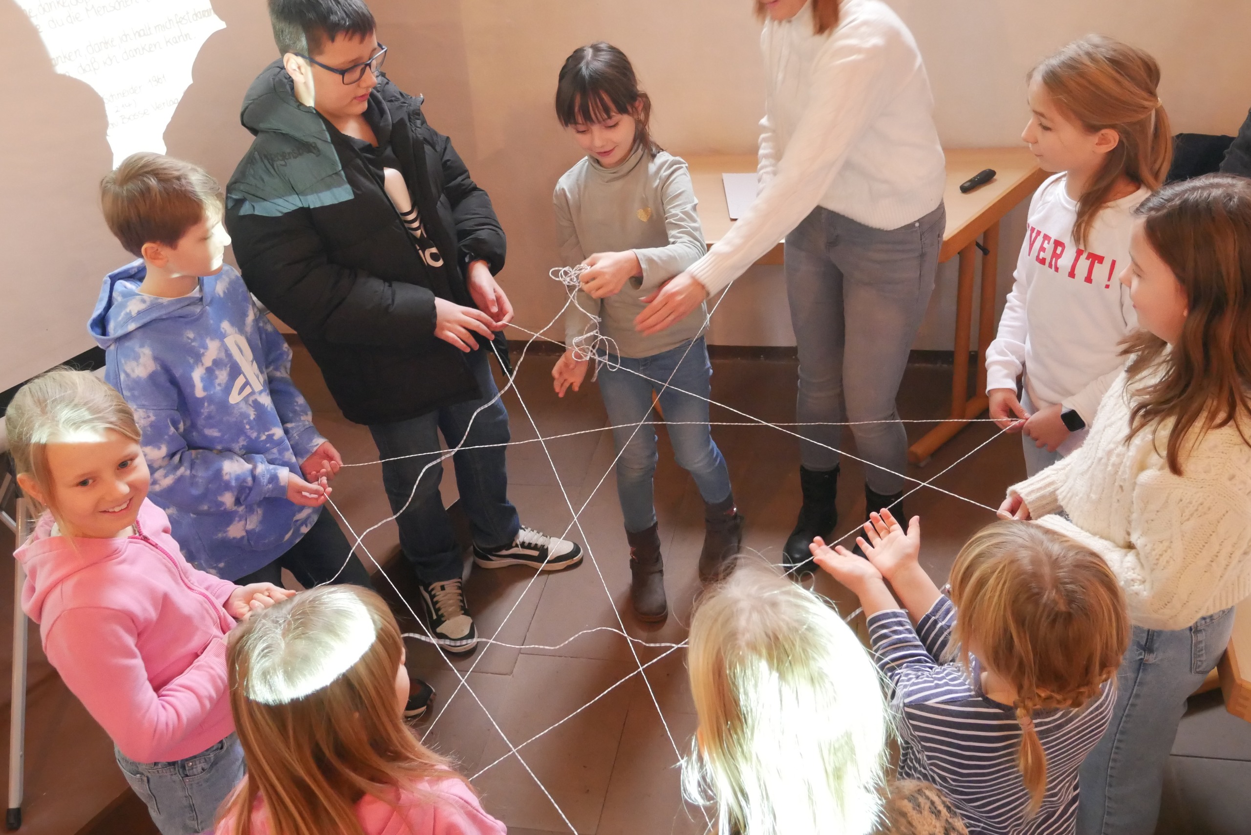 Kinder machen mit Seilen ein Netz.