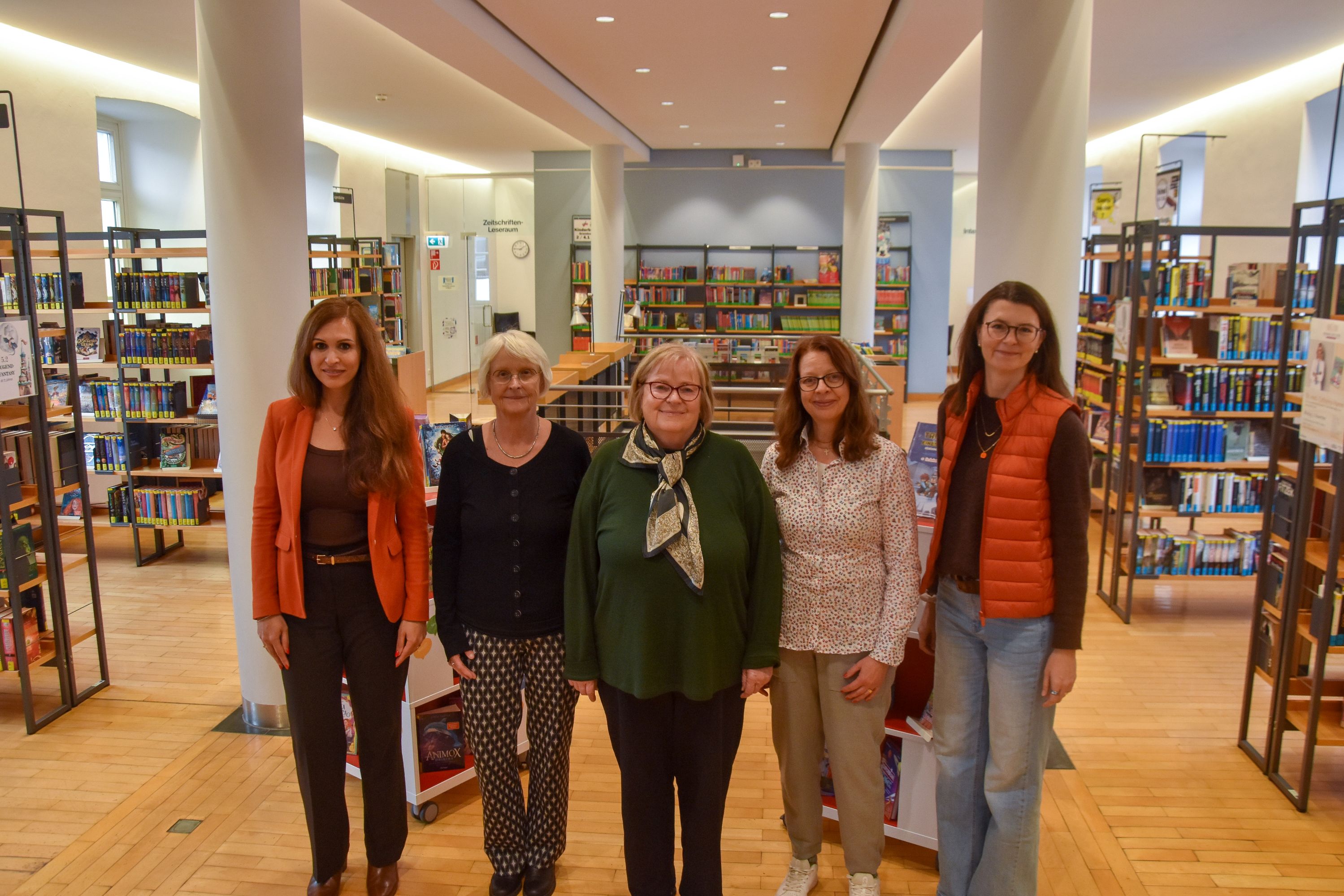 Gruppenbild mit fünf Frauen in einer Bibliothek.