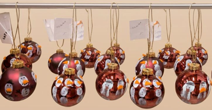 Das Bild zeigt mehrere Weihnachtsbaumkugeln, die an einer Stange hängen.