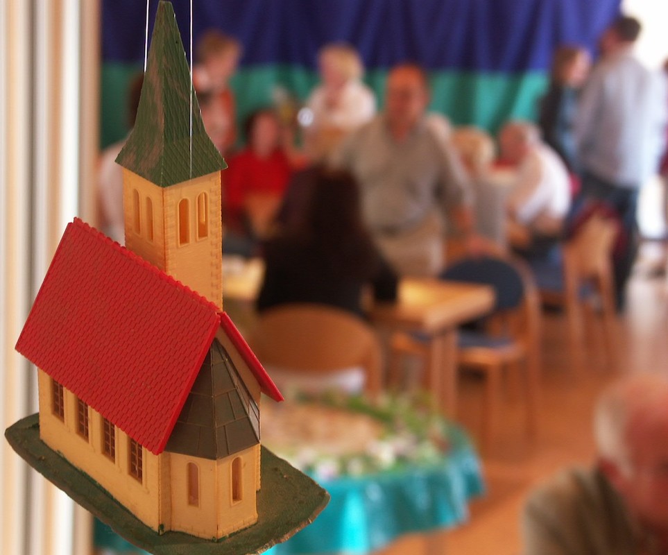 Modell einer Kirche mit Menschen im Hintergrund