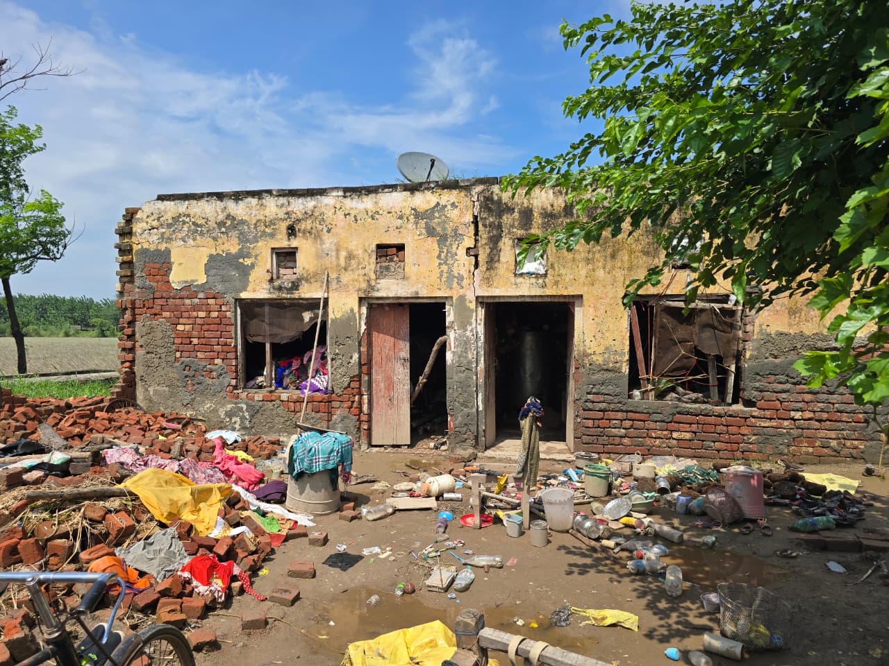 Ein zerstörtes Haus in Indien, vor dem Haus liegen Haushaltsgegenstände und Möbel.