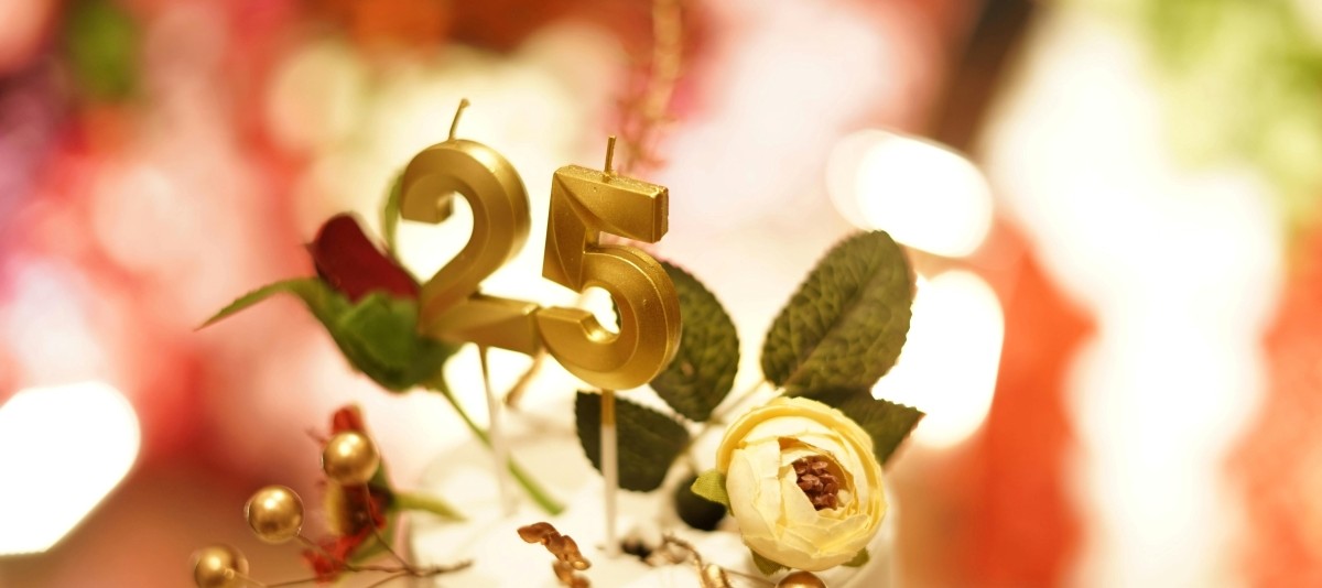 Tortenaufleger mit eingesteckten Rosen und goldenen Zahlenkerzen, Zahl 25