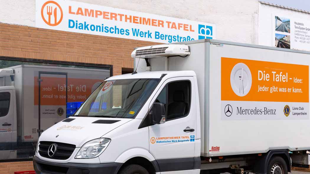 Kühltransporter der Lampertheimer Tafel steht vor der Ausgabestelle mit gut sichtbarem Schild „Lampertheimer Tafel – Diakonisches Werk Bergstraße“.
